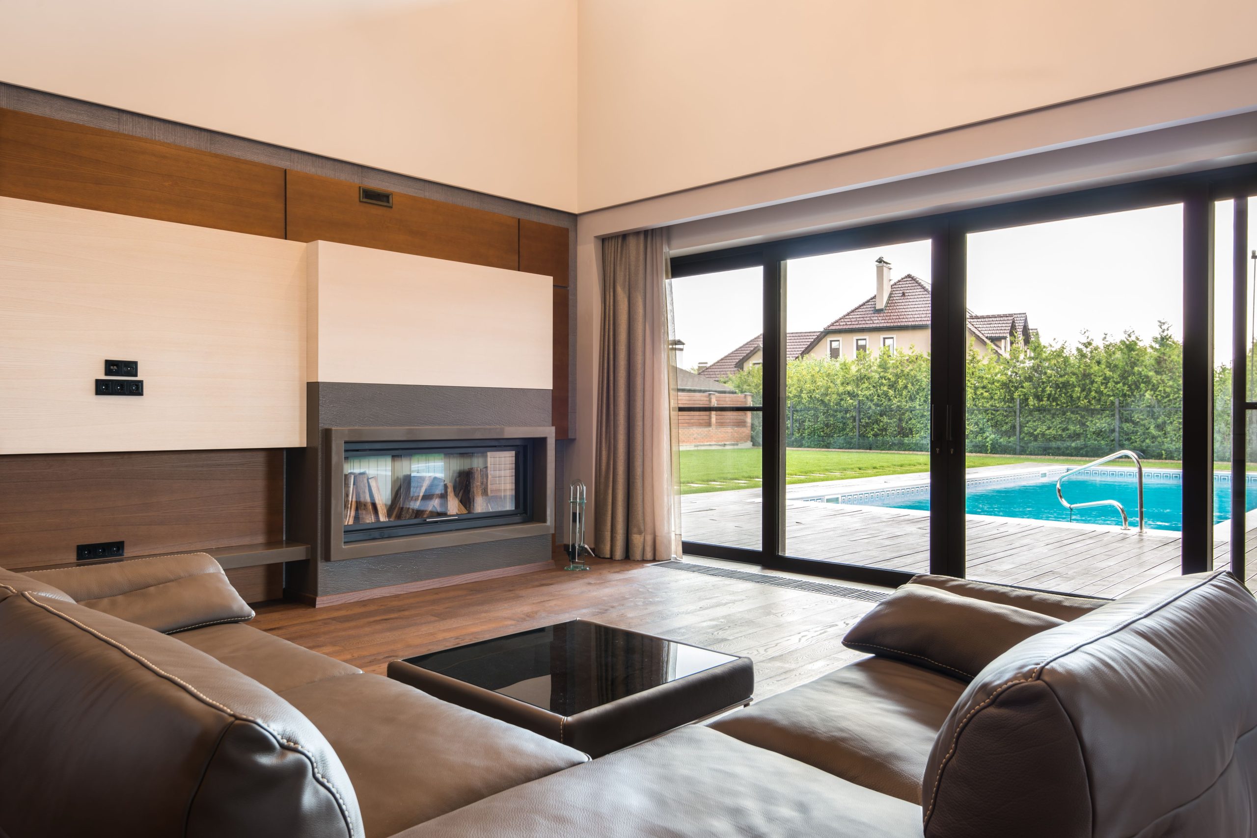 Strakke villa met glaspartijen uitkijkend op terras en zwembad. Foto: Max Vakhtbovych / Pexels.